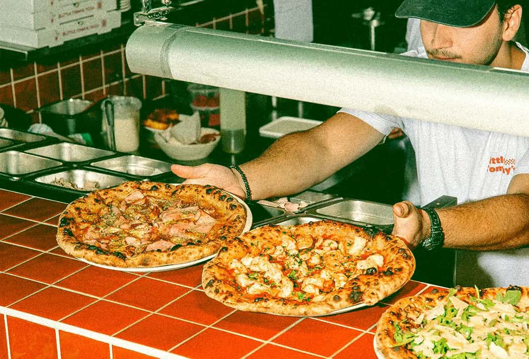 Due pizze appena sfornate servite al banco
